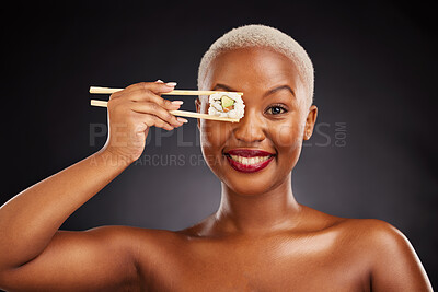 Buy stock photo Chopsticks, face and woman with sushi in studio for healthy eating, beauty and food. Portrait of a black female model with makeup on a dark background for wellness, diet or seafood advertising