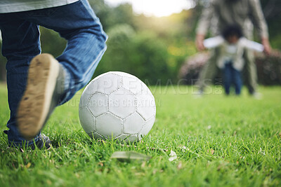 Buy stock photo Child, legs and kick soccer ball on grass for fun activity, childhood or playing in the park. Playful little boy in sports game or match for score, point or goal on green field in the nature outdoors