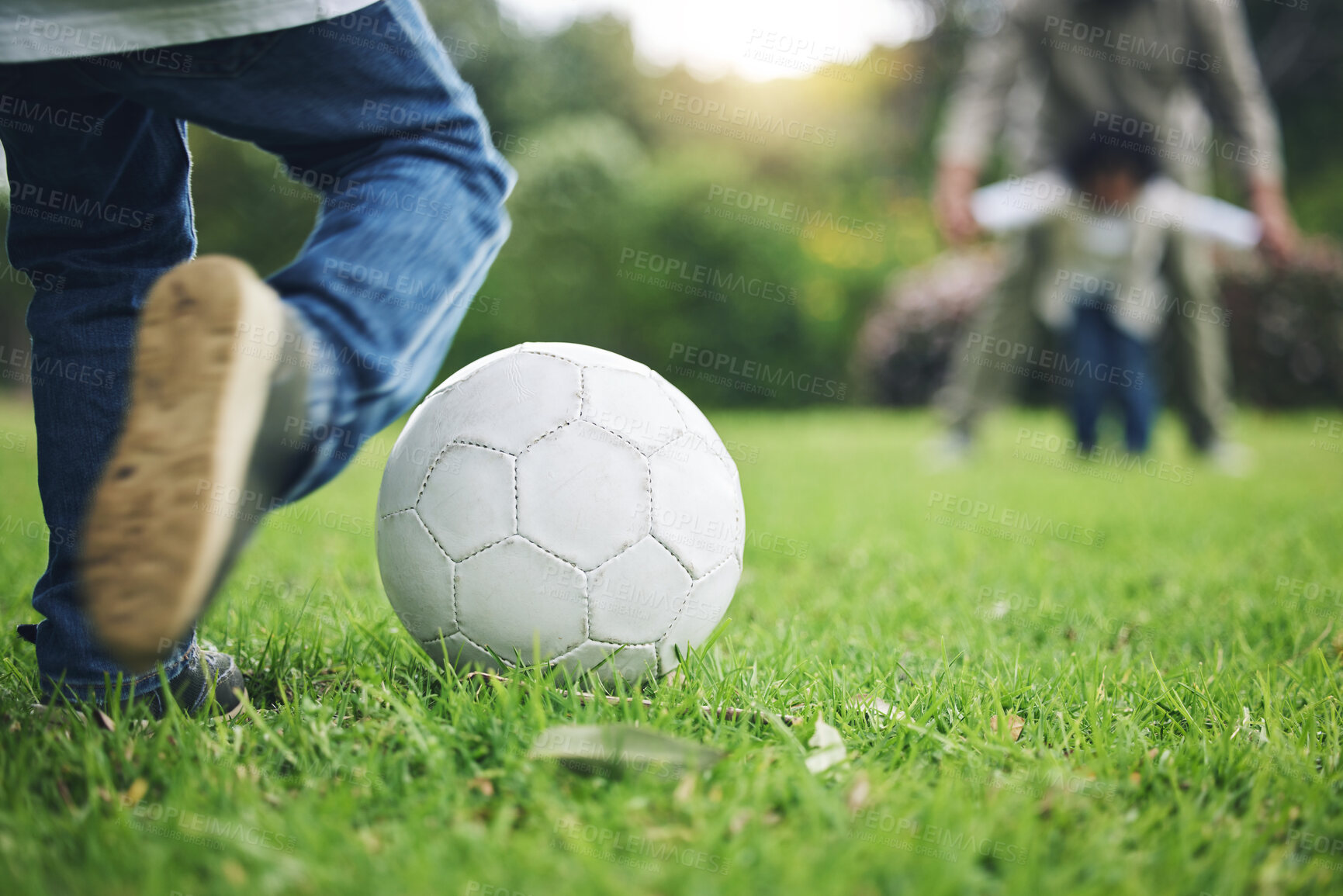 Buy stock photo Child, legs and kick soccer ball on grass for fun activity, childhood or playing in the park. Playful little boy in sports game or match for score, point or goal on green field in the nature outdoors