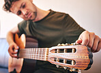 Closeup, man and tuning guitar for music, talent and creative skill of sound production in home studio. Hands, musician and singer check notes of acoustic instrument for audio, performance and artist