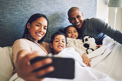 Buy stock photo Parents, children or family selfie in a bed together with love, care and security or comfort. Woman, man and kids with a happy smile for quality time or profile picture in a home bedroom to relax