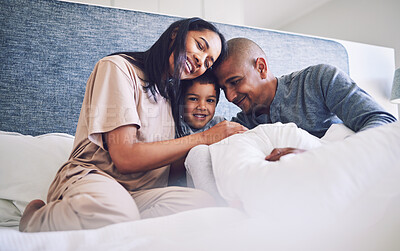 Buy stock photo Family home, parents and child in a bed together with love, care and security for comfort. Latino woman, man and kid with a happy smile, commitment and quality time in bedroom in the morning to relax