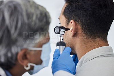Buy stock photo Woman, doctor and checking patient ear for flu, exam or healthcare appointment at the hospital. Female person or medical professional with protection looking at ill or sick man with flu at the clinic