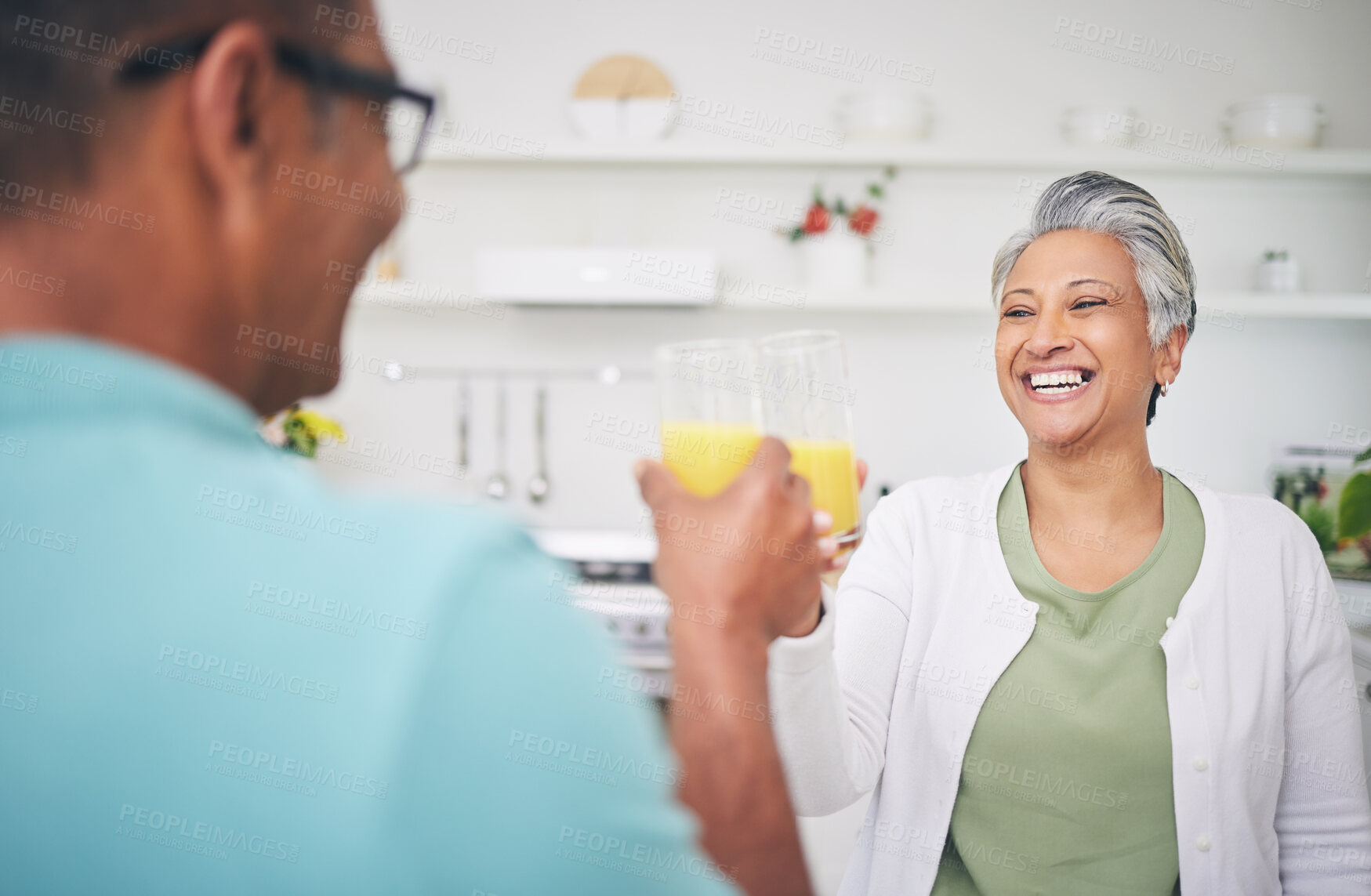 Buy stock photo Senior couple, smile and juice cheers in a kitchen with toast and love celebration drink. Home, glass and healthy cocktail of elderly man and woman happy of support and care with morning breakfast