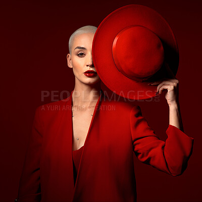 Buy stock photo Portrait, fashion and a model woman on a red studio background for elegant or trendy style. Aesthetic, art and beauty with a young female person looking edgy or classy in a suit or unique clothes