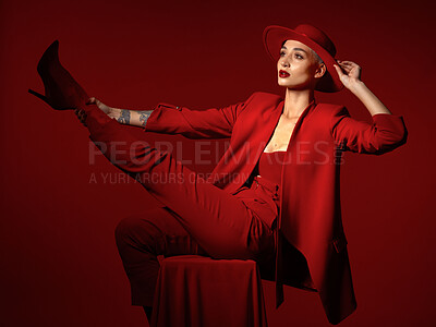 Buy stock photo Vision, fashion and a woman on a chair in studio on a red background for elegant or trendy style. Thinking, art and beauty with a young female person sitting in an edgy, classy or unique suit