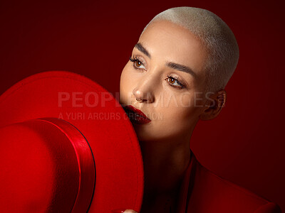 Buy stock photo Face, fashion and a model woman on a red studio background for elegant or trendy style. Future vision, art or beauty with a young female person thinking and looking edgy or classy in a unique outfit
