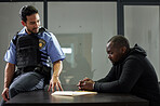Police, interrogation and black man, suspect or criminal investigation for crime at station. African person with handcuffs at table, detective and people in discussion, interview and law questions.