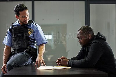 Buy stock photo Police, interrogation and black man, suspect or criminal investigation for crime at station. African person with handcuffs at table, detective and people in discussion, interview and law questions.