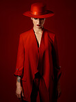 Fashion, suit and hat on woman with beauty in studio with retro, style and edgy, confident or creative pose on red background mockup. Mystery character, model and girl with power or vintage aesthetic
