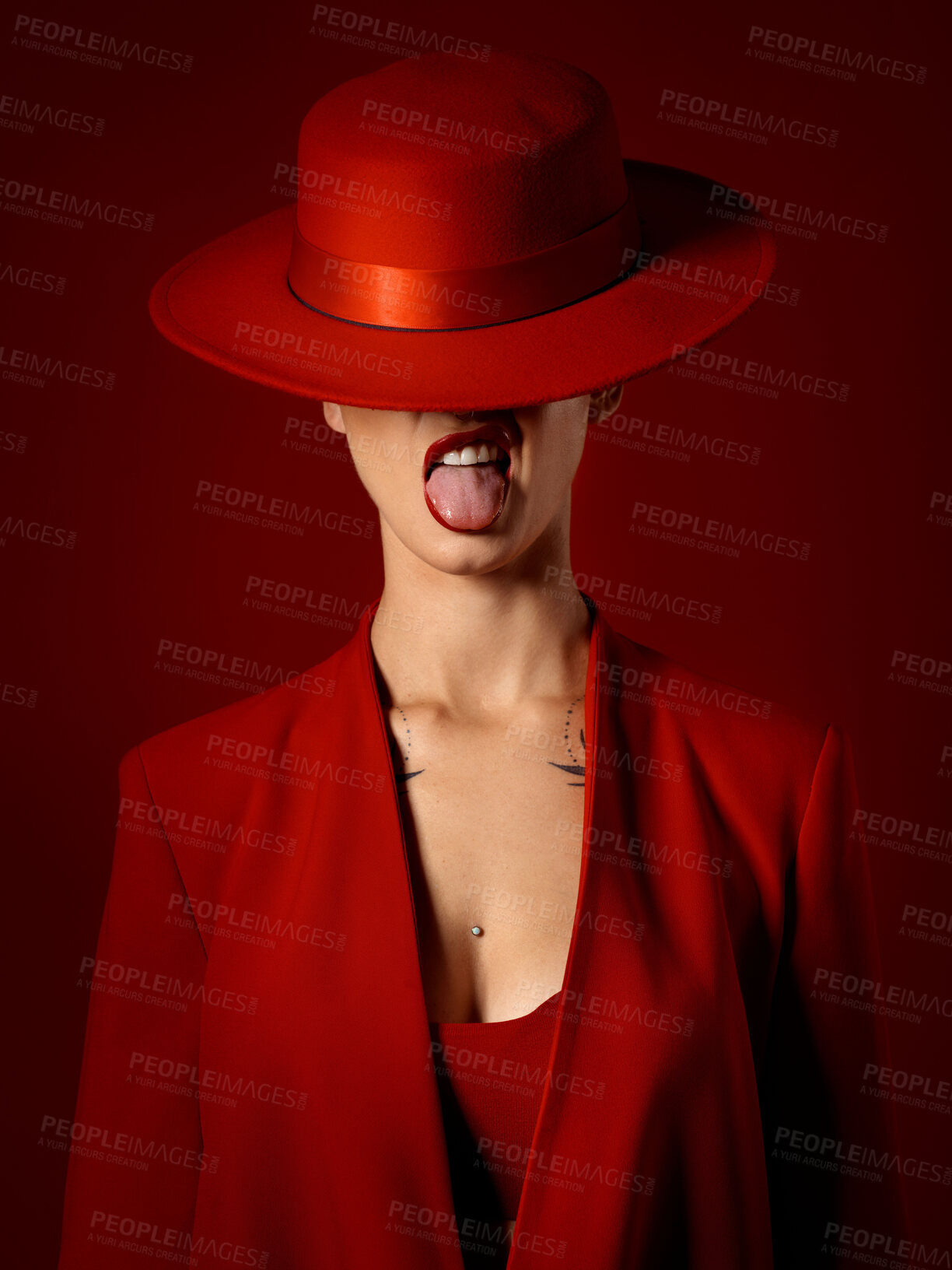 Buy stock photo Woman, red aesthetic and beauty with hat, makeup art and tongue out for couture, emoji and studio background. Girl, model and high fashion with suit, mindset and sexy with lipstick for cosmetics