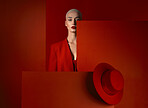 Portrait, fashion and space with a woman on a red background in studio for marketing, advertising or branding. Luxury, aesthetic style or a trendy young model standing with empty or blank mockup