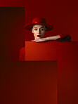 Portrait, fashion and space with a woman on a red studio background for marketing, advertising or branding. Luxury, aesthetic style or a trendy young female model standing with empty or blank space