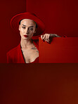 Portrait, red fashion and mockup with a woman on a studio background for marketing, advertising or branding. Luxury, aesthetic style or trendy young female in a hat standing with empty or blank space