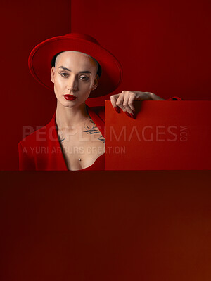 Buy stock photo Portrait, red fashion and mockup with a woman on a studio background for marketing, advertising or branding. Luxury, aesthetic style or trendy young female in a hat standing with empty or blank space