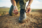 Hands, tie shoes and hiking in nature for travel, training or adventure outdoor. Fitness, sports and person tying laces on sneakers to start workout, walk or running, cardio or workout in countryside