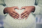 Pregnancy, closeup and woman with a heart shape on her maternal belly for care and motherhood. Health, zoom and African pregnant female person hands on stomach with a love sign or emoji for her baby.