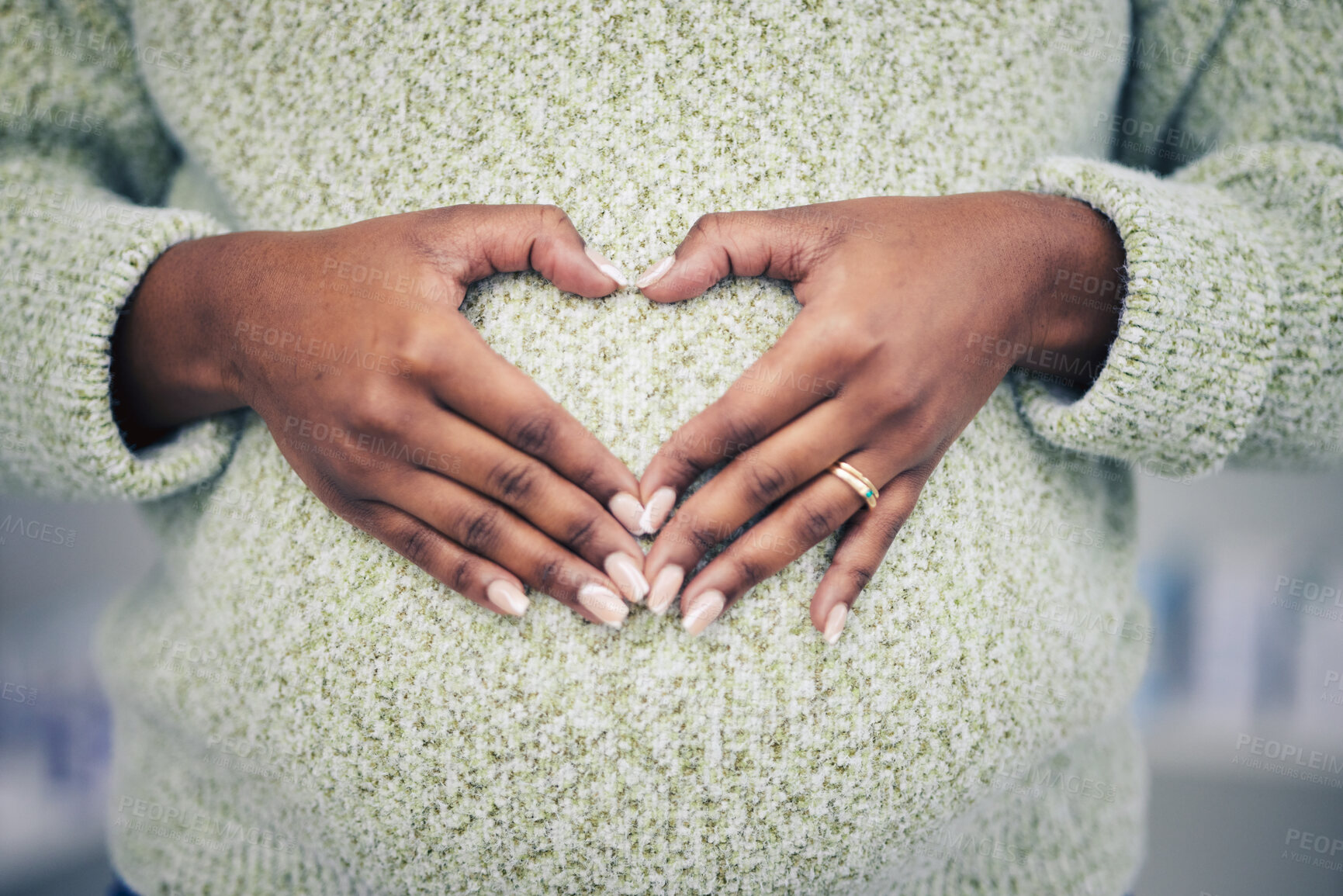 Buy stock photo Pregnancy, closeup and woman with a heart shape on her maternal belly for care and motherhood. Health, zoom and African pregnant female person hands on stomach with a love sign or emoji for her baby.