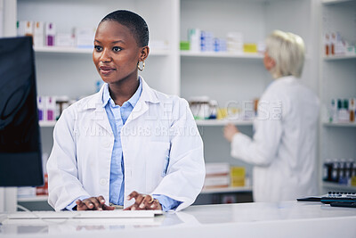 Buy stock photo Pharmacist, typing and black woman on computer in pharmacy, drugstore or shop. Wellness, medical professional and African doctor on internet for telehealth email, healthcare and research for medicine