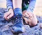 Shoes, tying laces and a person for fitness, mountain hiking or start training for sports. Nature, exercise and closeup hands of an athlete with feet and ready for running, workout or cardio