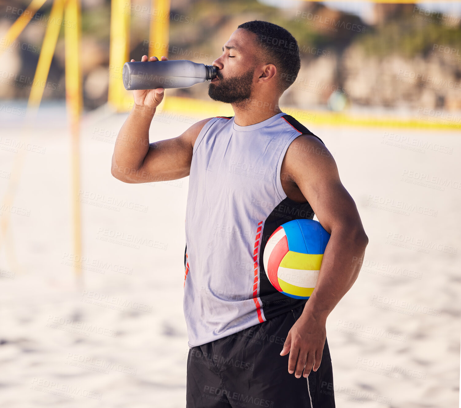 Buy stock photo Volleyball, drinking water and fitness of man on beach for training, competition and outdoor game break. Tired, handball and athlete or person with sports bottle on sand in summer or holiday wellness