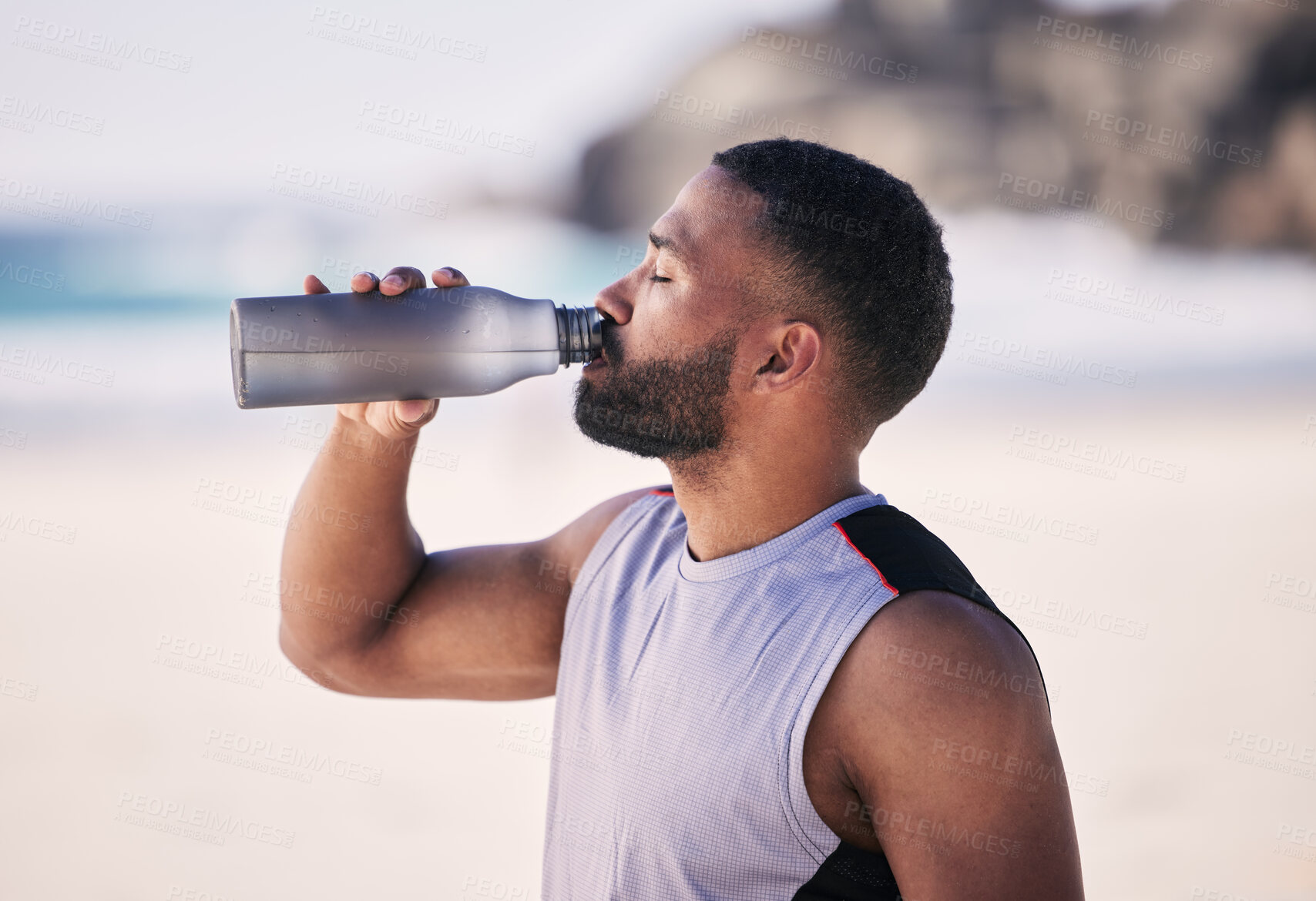 Buy stock photo Beach, exercise and man drinking water after running, workout or cardio fitness for health. Hydration, drink and thirsty male  and runner person with bottle at sea for training, wellness or sports