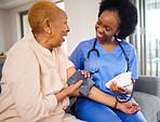 Black woman, nurse and caregiver for blood pressure, elderly care or healthcare on sofa at home. African female person or medical professional helping or monitoring old age patient in living room