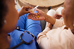 Healthcare, closeup of a nurse with medication for her patient in nursing recovery center. Checkup, medical and top view zoom of caregiver with medicine treatment for senior woman at retirement home.