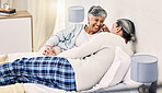 Happy, laugh and senior couple relax in bed with love, bond and holding hands with conversation. Old people, bedroom and speaking with smile, trust and soulmate connection while enjoying retirement 