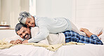 Senior couple, funny and playful on bed in home, hotel and happy together for romance, game or comic joke. Elderly woman, old man and funny on vacation, holiday or relax in bedroom, wrestling or love