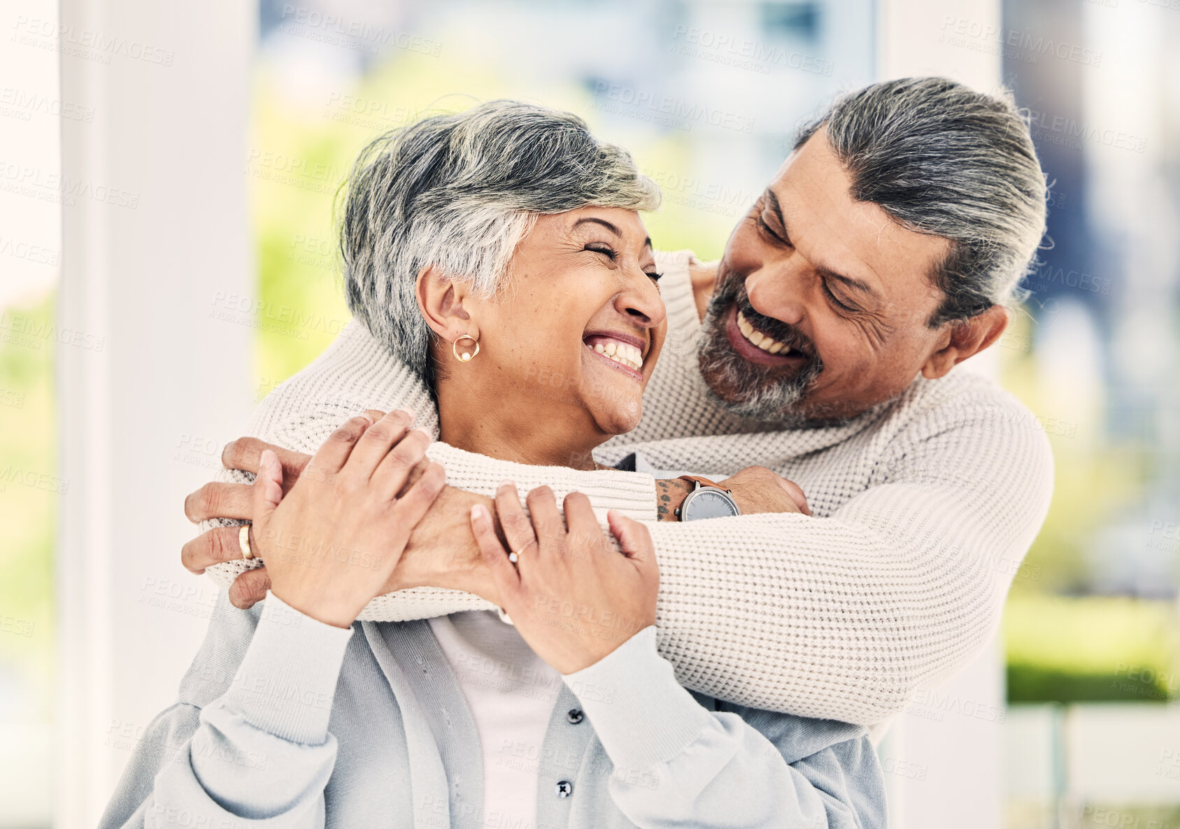 Buy stock photo Hug, home and senior couple with love, smile and retirement with happiness, quality time or loving together. Old woman, happy mature man or embrace in a lounge, bonding or romance with a relationship