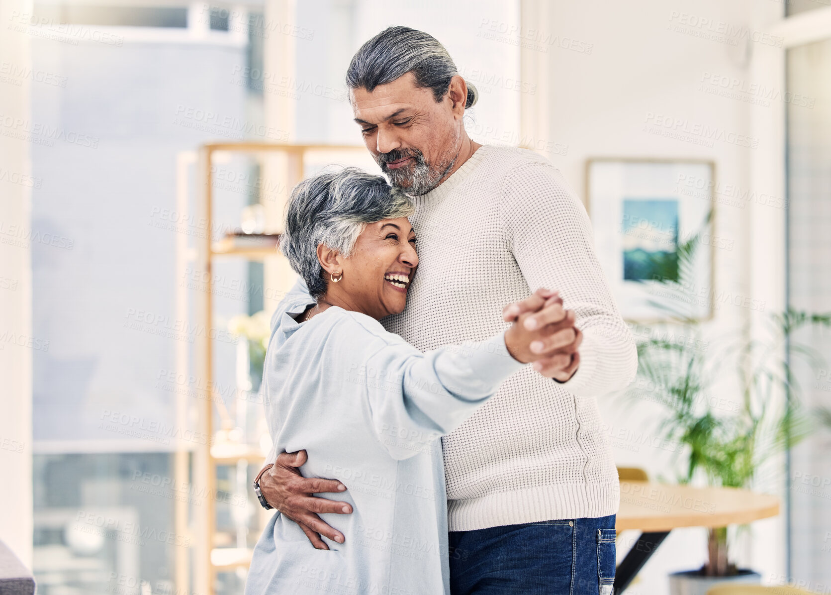 Buy stock photo Happy senior couple, holding hands and dance in living room for love, care or bonding together at home. Elderly man and woman hug enjoying quality time, retirement or celebration for anniversary