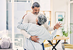 Senior couple, hug and holding hands in dancing for love, care or bonding together in living room at home. Elderly man and woman enjoying quality time, weekend or holiday celebration for anniversary