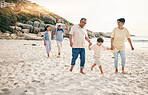 Holding hands, big family and walking at a beach for travel, vacation and fun in nature together. Freedom, parents and children relax with grandparents at the sea on holiday, trip or ocean adventure