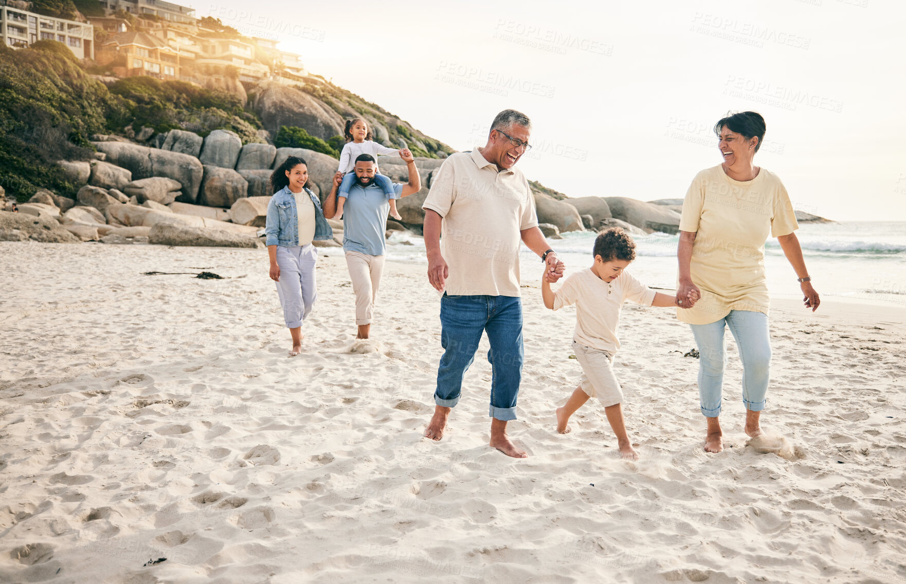 Buy stock photo Holding hands, big family and walking at a beach for travel, vacation and fun in nature together. Freedom, parents and children relax with grandparents at the sea on holiday, trip or ocean adventure