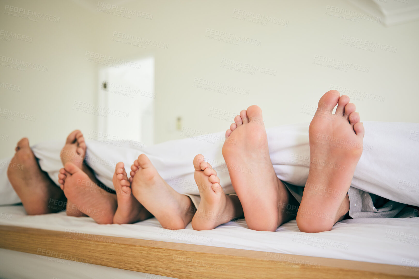 Buy stock photo Feet, sleep and family in a bed relax, resting and enjoying a weekend nap in their home. Sleeping, foot and children with parents in bedroom for dreaming, stress relief or vacation freedom in a house