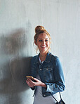 portrait young redhead woman using smartphone texting browsing social media messages smiling happy by concrete wall in city