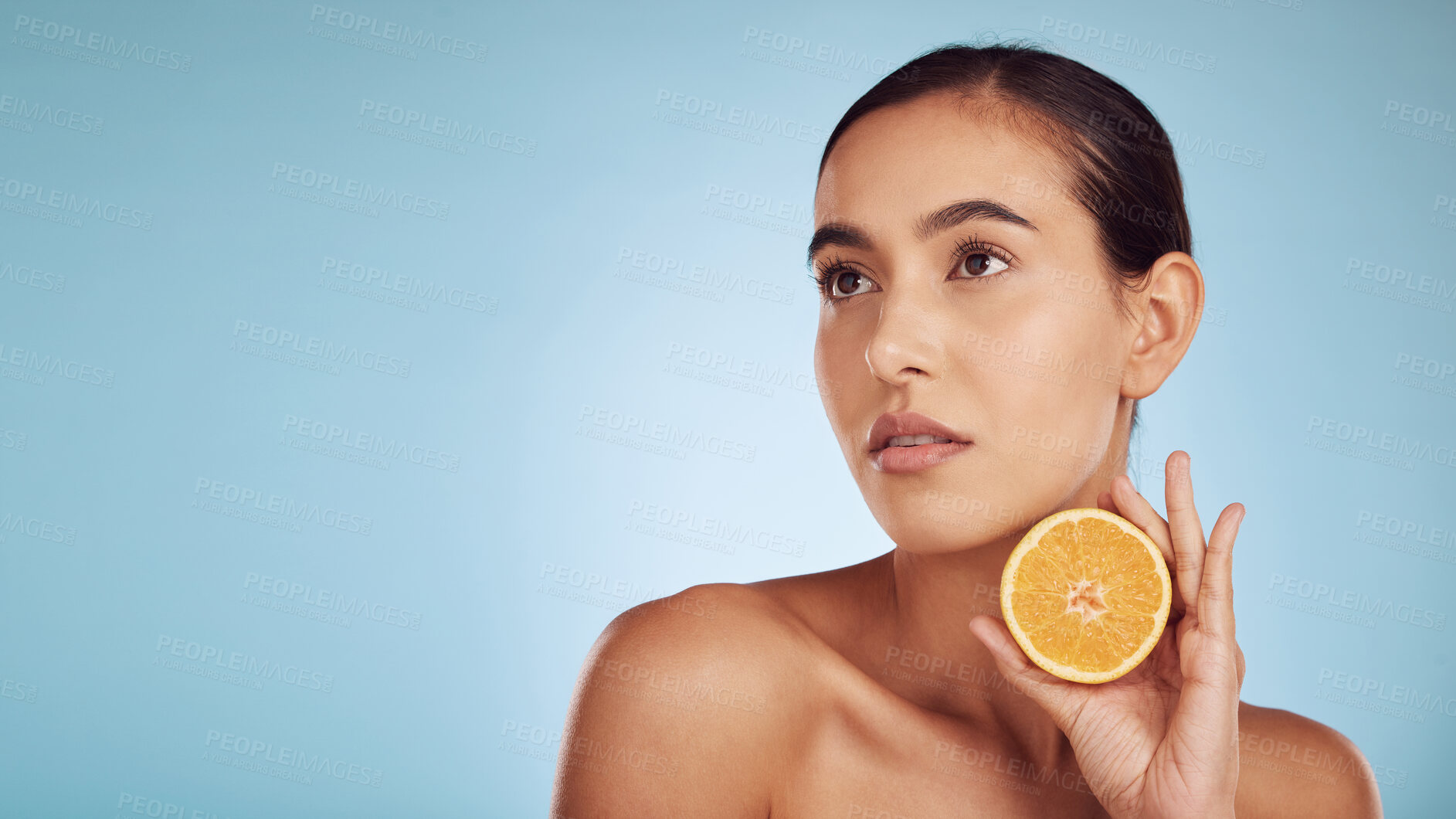 Buy stock photo Woman, orange and vitamin C on mockup for diet or skincare against a blue studio background. Female person, model or beauty with organic citrus fruit for natural nutrition, spa or facial treatment