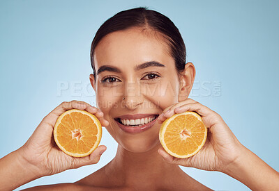 Buy stock photo Happy woman, portrait and smile with orange vitamin C, skincare or diet against blue studio background. Female person with organic citrus fruit for natural nutrition, dermatology or healthy wellness