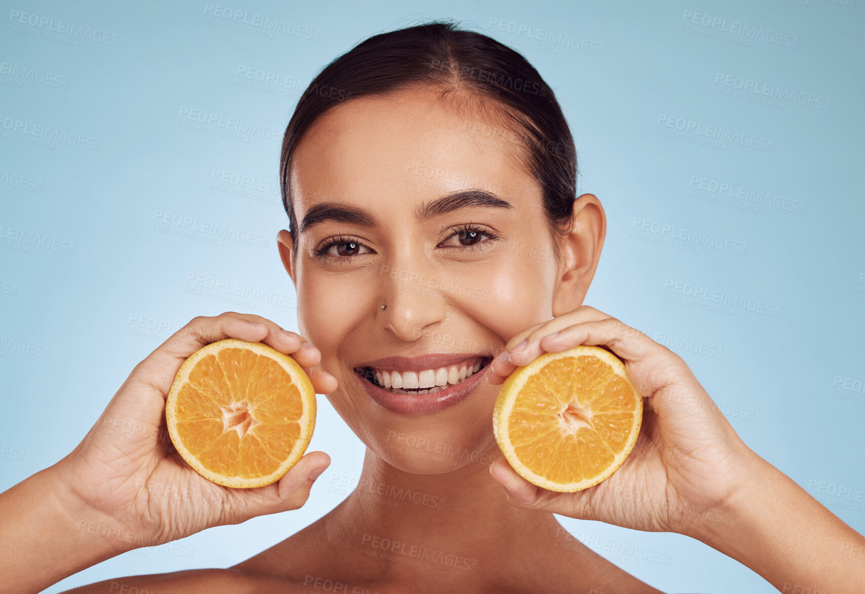 Buy stock photo Happy woman, portrait and smile with orange vitamin C, skincare or diet against blue studio background. Female person with organic citrus fruit for natural nutrition, dermatology or healthy wellness