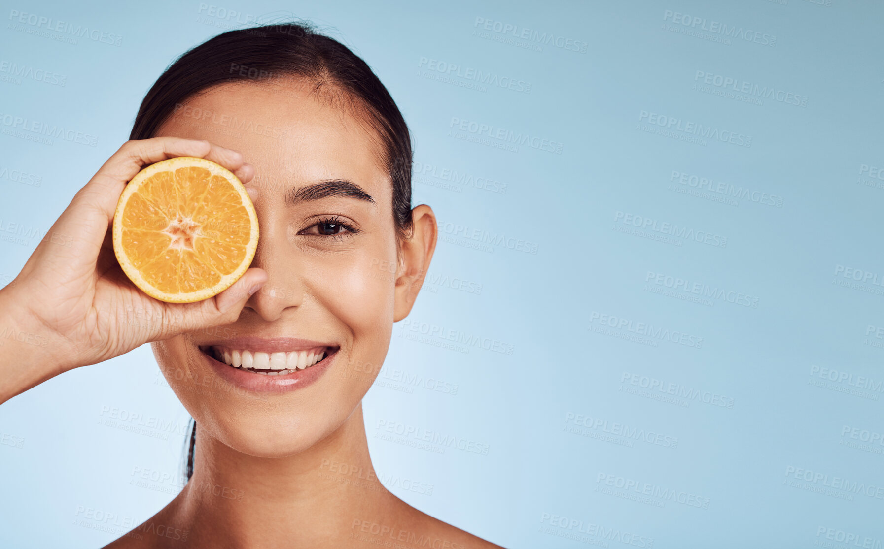 Buy stock photo Natural woman, portrait and orange for skincare, vitamin C or diet against a blue studio background. Person smile with organic citrus fruit for nutrition or facial treatment on mockup space or banner