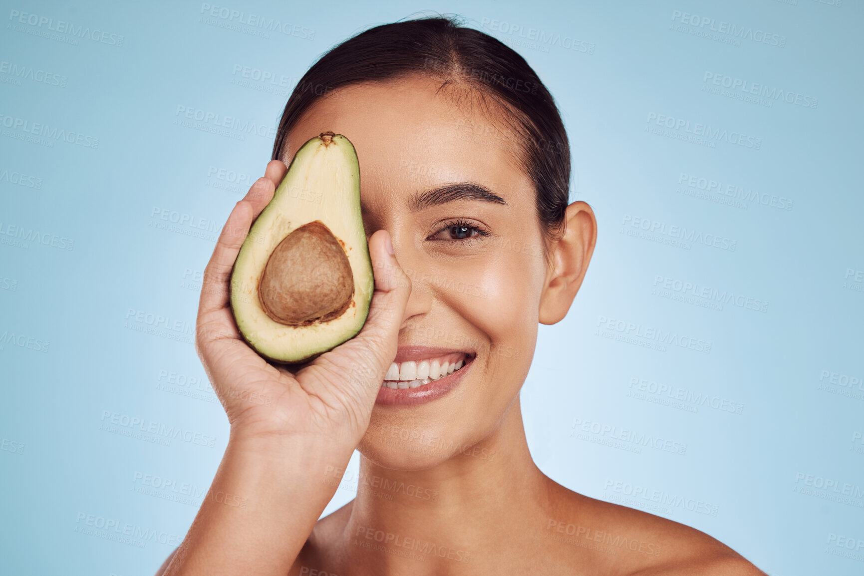 Buy stock photo Avocado, eye skincare and woman in portrait for healthy face or natural cosmetics on studio blue background. Happy person or model of green fruits, vitamin d benefits and dermatology or beauty health