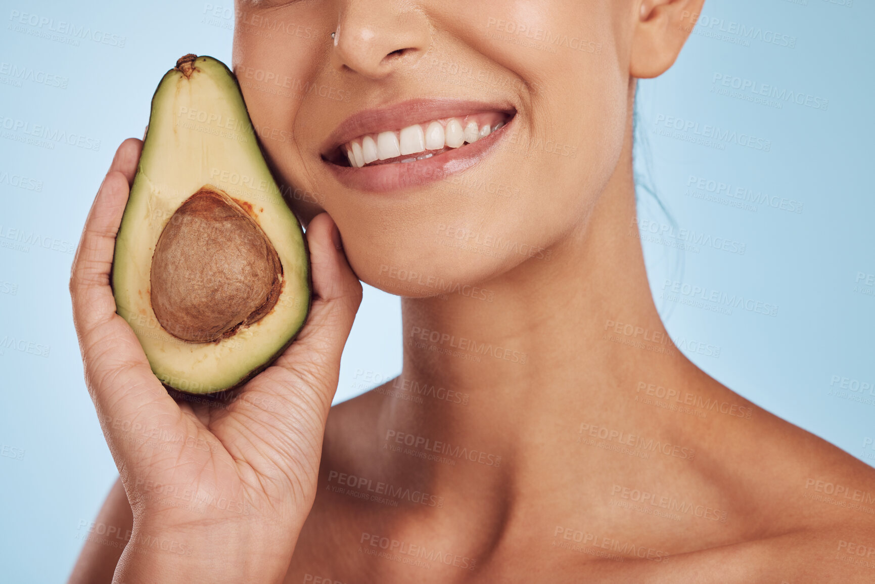 Buy stock photo Skincare, beauty and smile, woman with avocado, natural makeup and facial detox on blue background. Health, wellness and mouth of model, organic luxury cleaning and cosmetics with fruit in studio.