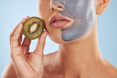 Buy stock photo Fruit, face mask and woman with kiwi for organic skincare or cosmetic treatment isolated in a blue studio background. Skin, beauty and young female person with facial wellness, nutrition and detox