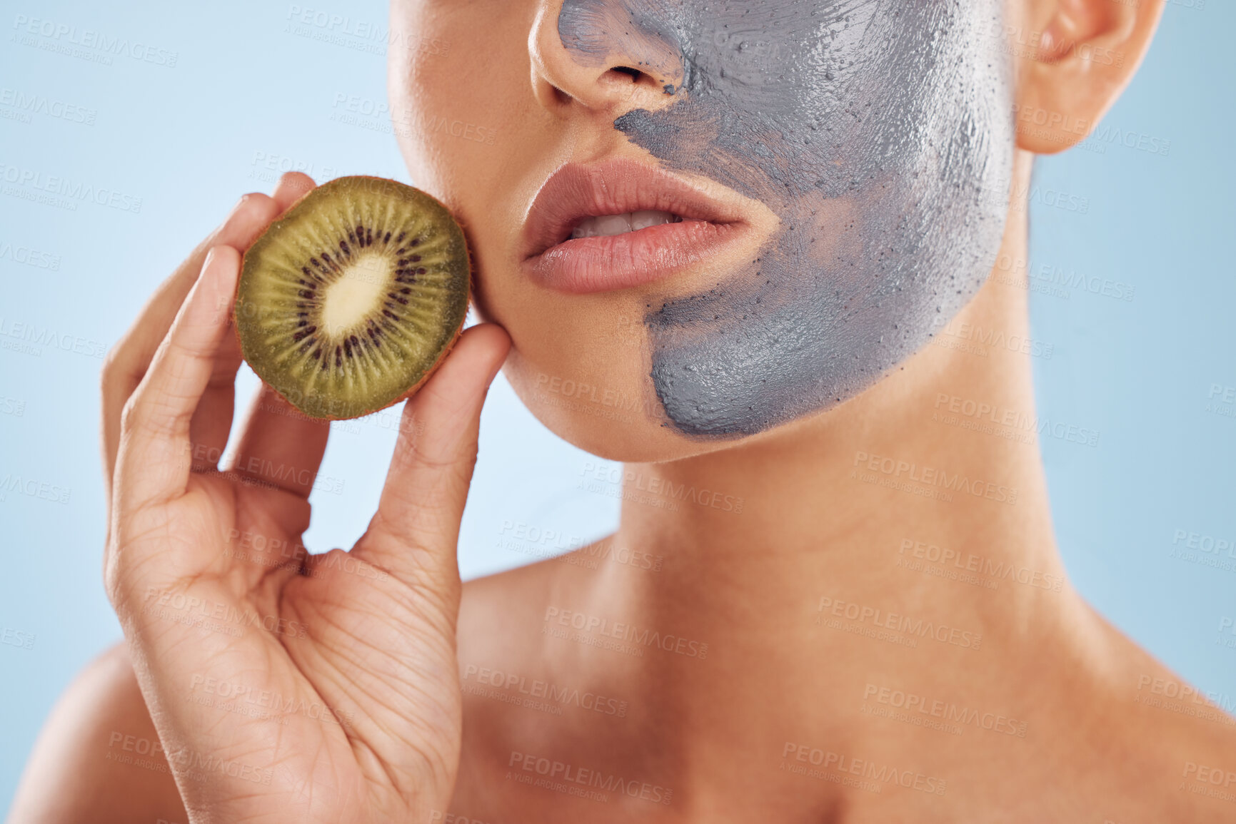 Buy stock photo Fruit, face mask and woman with kiwi for organic skincare or cosmetic treatment isolated in a blue studio background. Skin, beauty and young female person with facial wellness, nutrition and detox