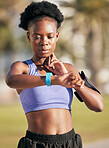 Fitness, exercise and woman checking her pulse with smartwatch for running outdoor in nature. Sports, workout and African female athlete monitoring heart rate for cardio training for race or marathon