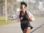 Fitness, black woman and running outdoor with music earphones for listening to radio on podcast. Sports, smile and happy African athlete training, workout and exercise for health, wellness or cardio