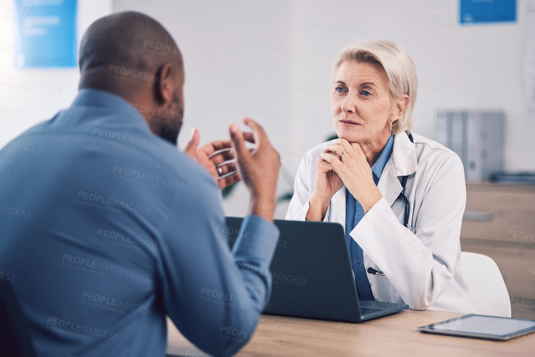 Buy stock photo Woman, doctor and listening to man in consultation for healthcare advice at clinic. Mature medical professional consulting with patient for support, wellness services and communication in hospital 