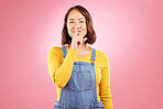 Woman, portrait and finger on lips for secret, news and privacy on isolated pink background in studio. Asian person, hand gesture and shush emoji for quiet, whisper and noise control on mockup space