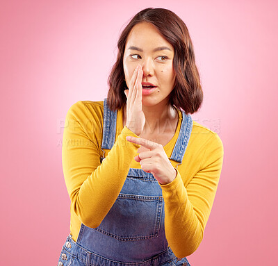 Buy stock photo Whisper, hand pointing and asian woman in studio with gossip, drama or hush news on pink background. Secret, did you know and Japanese female with emoji for confidential, privacy or coming soon promo